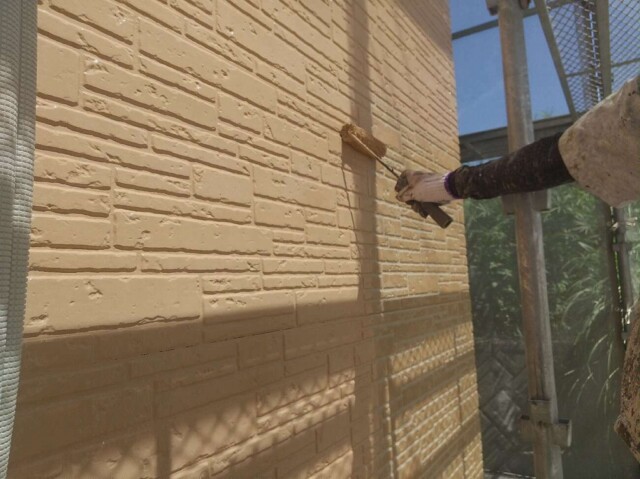 タイル調外壁サイディング<br />
（中塗り塗装）<br />
<br />
こちらの外壁には、耐候性に極めて優れた4フッ化フッ素樹脂を使用したフッ素樹脂塗料を塗装していきます。<br />
紫外線や雨、風、塩害など過酷な気象条件に強いというメリットがあり、長期に渡って建物の美観を保つことでメンテナンスの回数を確実に減らし、トータルコスト削減になります。<br />
